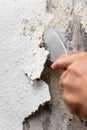 Old woodchip wallpaper is removed or scraped off the wall with a spatula