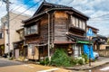 Old, wooden abandoned ghost house in Kanazawa, Japan with japanese carved roof, overgrown plants and trash. Royalty Free Stock Photo