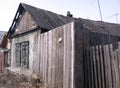 An old wooden abandoned house with closed Windows dirty