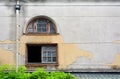 Old wooden arch window with red brick frame and water pipe for rain draining on cracked cement wall background Royalty Free Stock Photo