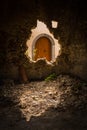 An old wooden arched door in Sicily seen through a broken hole i
