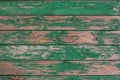 Old wooden background consisting of frayed textured boards, painted with green paint, which peeled off.