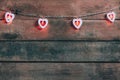 Old wooden background with a garland of red burning hearts. The concept of a Declaration of love, romantic relationships