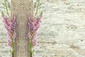 Old wooden background with heather and sacking ribbon