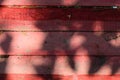Old wooden background made of horizontal boards, painted in red paint, with shadows and sunlight. Royalty Free Stock Photo