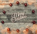 Old wooden background. With red balls, Merry Christmas text in the center, top view Royalty Free Stock Photo