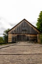 Old wooden barn with a set of train tracks on a bridge leading to it Royalty Free Stock Photo