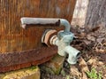 Old wooden barrel, rusty iron hoop, copper tap outdoors in sunlight Royalty Free Stock Photo