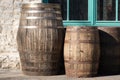 Old wooden barrels or casks at brewery backyard on a sunny day. Wine or beer oak vintage containers with stone wall texture Royalty Free Stock Photo