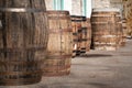 Old wooden barrels or casks at brewery backyard on a sunny day. Wine or beer oak vintage containers with stone wall texture Royalty Free Stock Photo