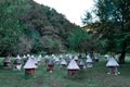 Old wooden bee hives of cylindrical shape in triangular roofs and caps stand among trees in green forest in mountains, Abkhazia