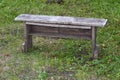 Old wooden bench on a background of green grass Royalty Free Stock Photo