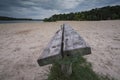 Old wooden bench on sand river bank at cloudy sunset Royalty Free Stock Photo
