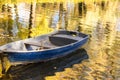 An old wooden boat on the pond. Autumn forest in the background. Royalty Free Stock Photo