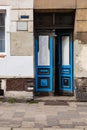 Old wooden blue doors in wall of old tenement building Royalty Free Stock Photo