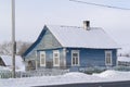 Old wooden blue house in village. Farmhouse in Belarus. View of rustic ethnic house, rural landscape in winter day