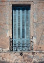 Old wooden blue window with metal hence in old house in decay