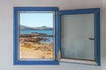 Old wooden blue window with the view of the beach in the background Royalty Free Stock Photo