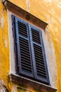 Old wooden blue window on yellow wall