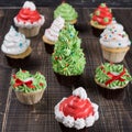 On old wooden boards there are many festive cupcakes, the concept of the approaching Christmas