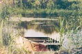 Old wooden boat anchored on the shores of the lake. Calm sunset on the nature. Fishing boat at the pier, reflections in water, Royalty Free Stock Photo