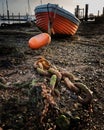 An old wooden boat chained to an anchor at low tide Royalty Free Stock Photo