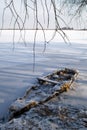Old wooden boat covered with snow froze in the ice near the shore Royalty Free Stock Photo