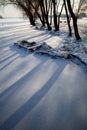 Old wooden boat covered with snow froze in the ice near the shore