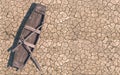 Old wooden boat on dry cracked soil. Dry river due to global warming. Climate change on Earth. Creative conceptual illustration