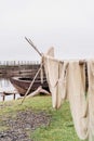 Old wooden boat and fishing net on the shore of beautiful misty lake and autumn forest landscape. Autumn forest and lake Royalty Free Stock Photo