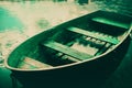 An old wooden boat floating by the riverbank on a summer day. Nostalgia and the connection between people and their natural