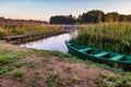 Old wooden boat in the reed bushes on the bank of wide river or lake Royalty Free Stock Photo