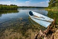 Old wooden boat in the reed bushes on the bank of wide river or lake Royalty Free Stock Photo