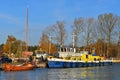 Old wooden boat with single mast and a small tugboat or icebreaker in port of Katy Rybackie Royalty Free Stock Photo