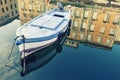 Old wooden boat, sky and ancient historical and building with reflection on blue water Royalty Free Stock Photo