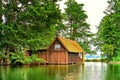 Old wooden boathouse with small window under trees at Schweriner See. Mecklenburg-Vorpommern Germany