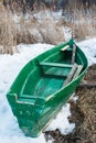 Old wooden boats lie in the snow on the shore of an ice-covered frozen lake in the winter. Royalty Free Stock Photo