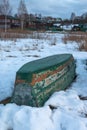 Old wooden boats lie in the snow on the shore of an ice-covered frozen lake in the winter. Royalty Free Stock Photo