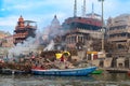 old wooden boats at the pier on the border of river Ganges in morning light with people on pier in Varanasi Royalty Free Stock Photo