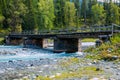 Old wooden bridge across mountain river.Altai Mountains, Russia. Sunny summer day Royalty Free Stock Photo