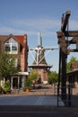 Old wooden bridge with arch and hanging chains and the mill