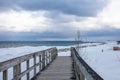 An old, wooden bridge crosses a section of frozen Georgian Bay waterfront in Collingwood