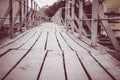 An old wooden bridge with girdles handrails. City road from the boards. The way through the industrial quarter of the town to go