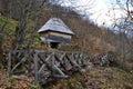 Old wooden bridge leading to the old barn on the slope of the hill in the autumn forest Royalty Free Stock Photo