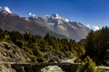 Old wooden bridge over marsyandgi river and snowy mount pisang peak in the background in annapurnas of nepal Royalty Free Stock Photo