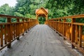 Old wooden bridge over the river with arbor. Forest River.