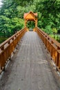 Old wooden bridge over the river with arbor. Forest River.