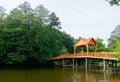 Old wooden bridge over the river with arbor. Forest River.