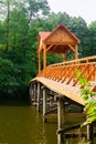 Old wooden bridge over the river with arbor. Forest River.