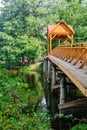 Old wooden bridge over the river with arbor. Forest River.